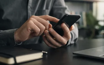 Persona che controlla un telefono per individuare segnali di sorveglianza digitale